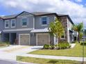 Attractive two-story townhouse featuring stone accents, a two-car garage, and lush landscaping at 14352 Editors Note St, Ruskin, FL 33573
