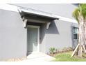 Inviting front entrance with a stylish gray door, covered porch, and manicured greenery at 14352 Editors Note St, Ruskin, FL 33573