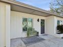 Inviting front porch with a green bench, decorative wreath, and neutral rug at 15801 Bridgewater Ln, Tampa, FL 33624