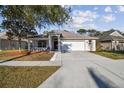 Charming single-story home features a well-manicured lawn, a two-car garage, and a covered front porch at 15807 Leatherleaf Ln, Land O Lakes, FL 34638