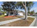 Well-maintained single-story home on a tree-lined street, featuring a spacious driveway and an attached two-car garage at 15807 Leatherleaf Ln, Land O Lakes, FL 34638