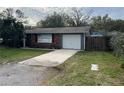 Cozy home featuring a single-car garage and a long concrete driveway at 16240 Lake Palm Dr, Lutz, FL 33549