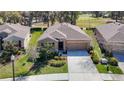 Aerial view of house with a well-maintained lawn, lush landscaping, and access to golf course at 17749 Garsalaso Cir, Brooksville, FL 34604