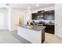 Modern kitchen with a large center island, granite countertops, and stainless steel appliances at 17749 Garsalaso Cir, Brooksville, FL 34604