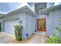 Inviting home exterior featuring a well-manicured lawn, front door, and attached garage at 18828 Rue Loire, Lutz, FL 33558