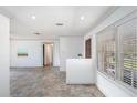 Bright living room with neutral paint, tile floors, and large windows with blinds for natural light at 202 Dunkirk Rd, Oldsmar, FL 34677