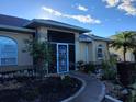 Beautifully landscaped front yard featuring a stone pathway leading to the screened front door at 28 Sportsman Pl, Rotonda West, FL 33947