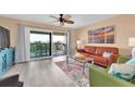 Cozy living room with sliding glass doors to a balcony, wood-look floors, and modern furnishings at 3111 Pass A Grille Way # 213, St Pete Beach, FL 33706