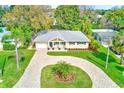Aerial shot of a landscaped home with a circular driveway and mature trees at 316 Barbara Cir, Belleair, FL 33756