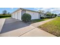 Exterior view showcasing the attached garage and well-manicured lawn at 3401 Stonehaven E Ct # A, Palm Harbor, FL 34684