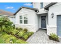 Inviting front entry with stone accents, lush landscaping, and a charming wreath on the door at 34303 Radley Way, Wesley Chapel, FL 33545