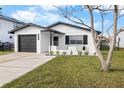 Charming single-story home featuring a well-manicured lawn and a freshly painted white exterior and black trim at 3515 Centavo Ct, Hernando Beach, FL 34607