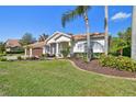 Well-maintained home featuring a lush green lawn, mature trees, and a tile roof at 3819 Brooksworth Ave, Tarpon Springs, FL 34688