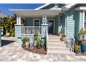 Inviting front porch with steps, potted plants, and decorative elements at 410 Georgia Ave, Crystal Beach, FL 34681