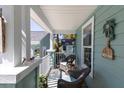 Relaxing front porch with wicker chairs and view of the shed and yard at 410 Georgia Ave, Crystal Beach, FL 34681