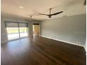 Open living room with hardwood floors and sliding glass doors to the pool at 514 Cedar Woods Dr, Oldsmar, FL 34677