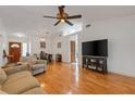 Bright living room featuring wood floors, neutral walls, ceiling fan, and view into adjacent dining area at 80 Squire Ct, Dunedin, FL 34698