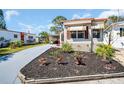 Charming single-story home showcasing well-maintained landscaping and a gray driveway at 807 Saint Charles Dr, Tarpon Springs, FL 34689