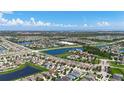 Expansive aerial view of a residential community featuring interconnected lakes and lush green spaces under a partly cloudy sky at 924 Peregrine Hill Pl, Ruskin, FL 33570