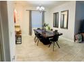 Elegant dining room featuring a large wooden table, modern chandelier and decorative mirrors at 924 Peregrine Hill Pl, Ruskin, FL 33570