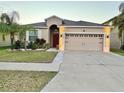 Charming single-story home featuring a well-manicured lawn, a two-car garage, and tropical landscaping at 924 Peregrine Hill Pl, Ruskin, FL 33570