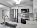 Modern kitchen with stainless steel appliances, white cabinetry, and quartz countertops at 9915 39Th N St # 3, Pinellas Park, FL 33782
