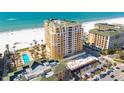 Beautiful aerial view of beachfront condo featuring a pool, palm trees, and stunning ocean views at 11 Baymont St # 1403, Clearwater Beach, FL 33767