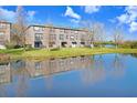 Townhome complex with beautiful pond view, grass lawn and blue sky at 1208 Chatham Pine Pl, Brandon, FL 33511