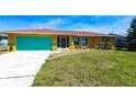 Charming single-story home featuring a vibrant blue garage door and a well-maintained front yard at 2466 Lake View Blvd, Port Charlotte, FL 33948