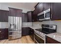 Well-equipped kitchen with stainless steel appliances, dark cabinetry, and granite countertops at 344A Bay St, Palm Harbor, FL 34683