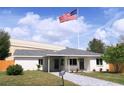 Charming single-story home featuring a manicured lawn, a gray walkway, and a prominent American flag at 4019 W Lemon St, Tampa, FL 33609