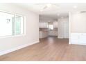 Bright living room with light hardwood floors flowing into a modern white kitchen at 4019 W Lemon St, Tampa, FL 33609