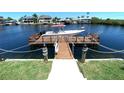 Dock with boat parked featuring boat lift and waterfront access with seawall at 4108 Daisy Dr, Hernando Beach, FL 34607