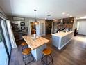 Open concept kitchen with brick accent wall, island seating, view to canal front patio at 4108 Daisy Dr, Hernando Beach, FL 34607