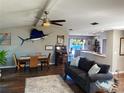 Inviting living room with dark wood floors, large windows, ceiling fan, and view of the backyard at 4108 Daisy Dr, Hernando Beach, FL 34607