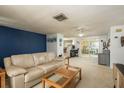 Bright living room featuring a comfortable couch, ceiling fan, and view into dining area at 6905 El Camino Paloma St, Port Richey, FL 34668
