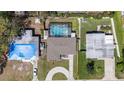 Aerial view of a home featuring a screened pool, spacious yard, and driveway at 8006 N Ola Ave, Tampa, FL 33604