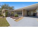 Inviting home featuring a covered entryway with stone accents and a well-maintained landscape at 8006 N Ola Ave, Tampa, FL 33604