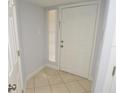 Bright entryway features neutral tile flooring, white door, and fresh paint at 8647 Mallard Reserve Dr # 104, Tampa, FL 33614