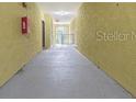 Hallway with concrete floors and yellow stucco-style walls, leading to an outdoor gated area at 10205 Courtney Palms Blvd # 304, Tampa, FL 33619