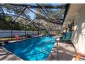 Inviting screened pool area with ample seating and a jacuzzi, perfect for relaxation and outdoor enjoyment at 12005 Wren Ct, New Port Richey, FL 34654