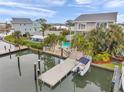 Aerial view of waterfront homes featuring a pool, private dock, boat and manicured landscaping at 17404 1St E St, Redington Shores, FL 33708