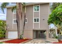 Two-story home with a garage, ample parking, and well-maintained landscaping, including tropical plants at 17404 1St E St, Redington Shores, FL 33708