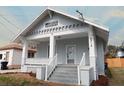 Charming home featuring a covered front porch, light grey painted exterior, and white trim at 2018 Elmwood Ave, Tampa, FL 33605