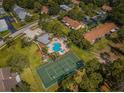 Aerial view of community amenities, including a pool, tennis court, and lush landscaping at 2446 Bentley Dr, Palm Harbor, FL 34684