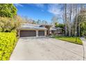 Charming single-story home with a three-car garage, manicured lawn, and beautiful landscaping at 3137 Valemoor Dr, Palm Harbor, FL 34685