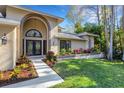 Charming single-story home with an arched entrance and beautiful landscaping at 3137 Valemoor Dr, Palm Harbor, FL 34685