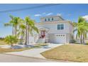 Two-story home with manicured landscaping and double garage, accented by palm trees at 3415 Croaker Dr, Hernando Beach, FL 34607
