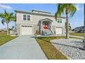 Inviting two-story home with a vibrant red door, a well-manicured lawn, and a convenient two-car garage at 3415 Croaker Dr, Hernando Beach, FL 34607
