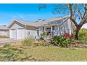Beautiful single-story house with a two-car garage surrounded by lush landscaping and mature trees at 39650 Us Highway 19 N # 244, Tarpon Springs, FL 34689